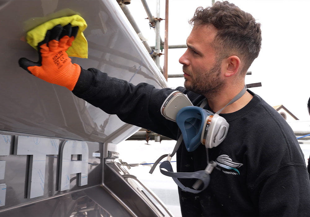 Photo of a man polishing the exterior of a boat